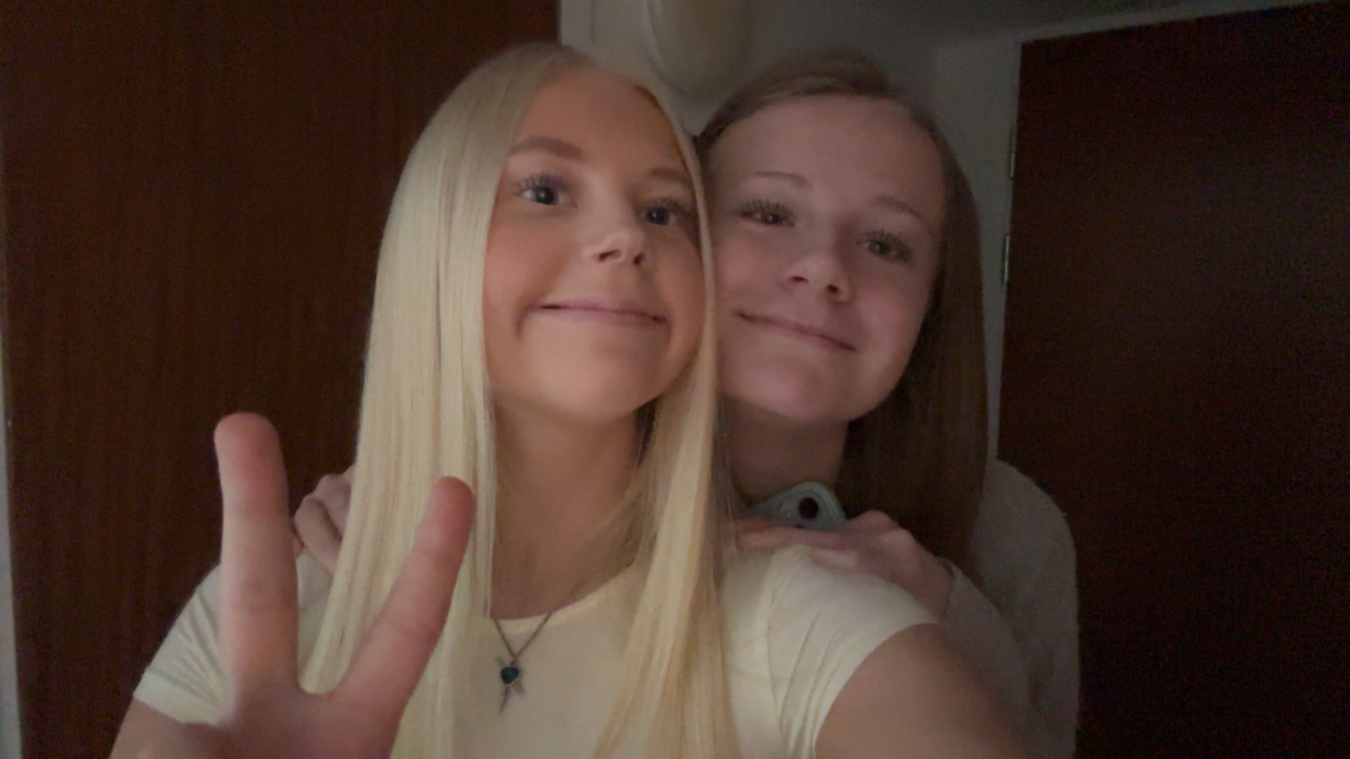 Två glada tjejer tittar in i kameran