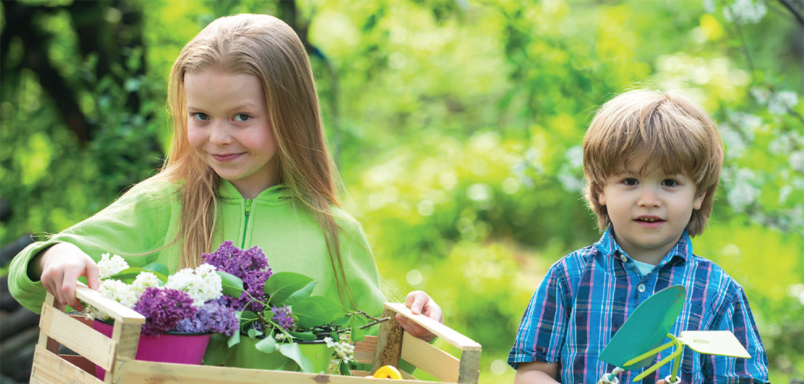 En flicka och en pojke med en korg blommor.