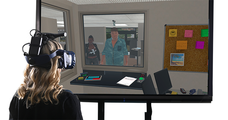 En kvinna med VR-headset tittar på en skärm med datoranimerade figurer.