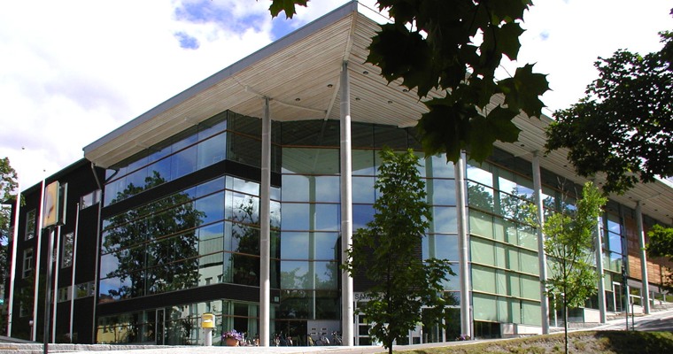 En kommunvägledare och en besökare vid en receptionsdisk, på disken finns Härnösands kommuns logga.