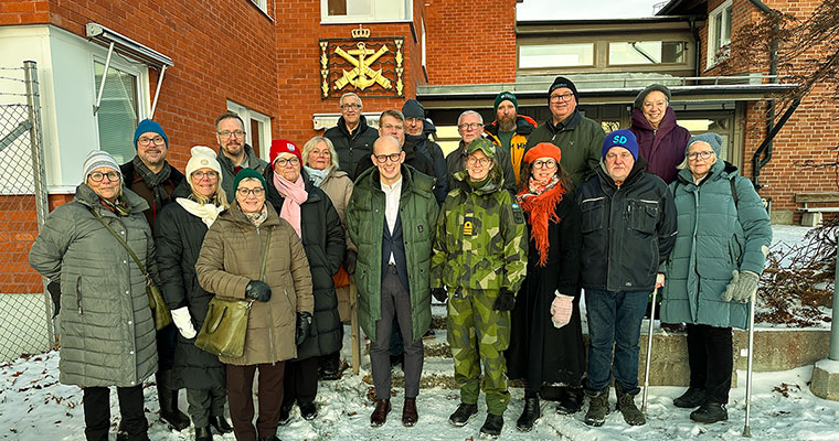 många människor står framför en röd tegelbyggnad