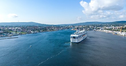 Flygbild på ett kryssningsfartyg på väg in mot en hamn