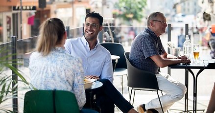 två personer sitter vid ett bord på en uteservering