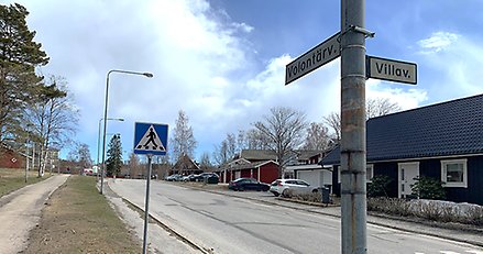 en gata med en gatuskylt i förgrunden där det står volontärvägen och villavägen