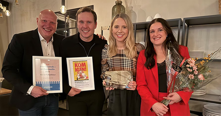 Fyra personer, två män och två kvinnor med blommor och diplom i händerna.