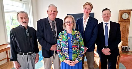 Fem leende personer, fyra män och en kvinna, uppställda för fotografering.