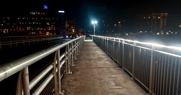 tillfälliga bron i mörker med belysning längs broräcket