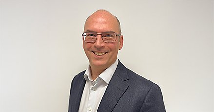 Porträttbild på Björn Hylenius iklädd vit skjorta, kavaj och glasögon.