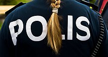 Ryggtavla på en oidentifierbar kvinnlig polis med fläta. Texten POLIS syns på ryggen.