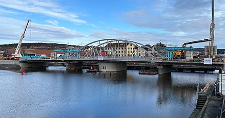 en nästan färdig bågbro över ett sund. 