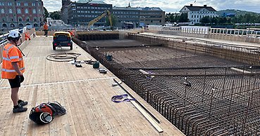 en man i arbetskläder står på ett brobygge