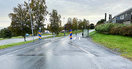 en gata som smalnar av vid en busshållplats