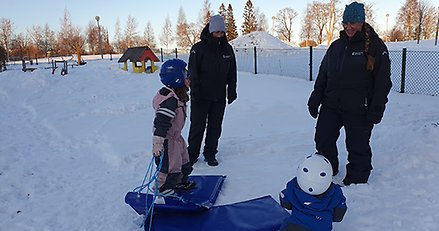 Förskolepersonal åker madrass med barn. 