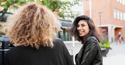 Två personer i stadsmiljö en sedd bakifrån och en framifrån.