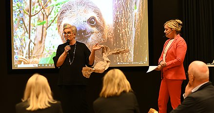 två personer står längst fram i en föreläsningssal