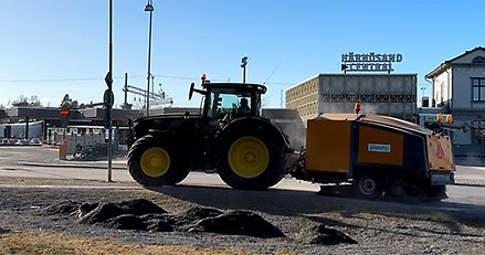 En traktor med en sopmaskin.