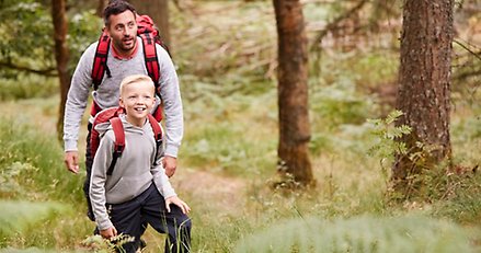 Pappa och son på utflykt i skogen.