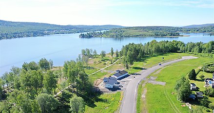 Vy över gata där det ligger två nybyggda villor och tomma tomter