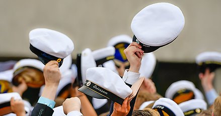 studentmössor, några på huvuden och några som höjs i luften