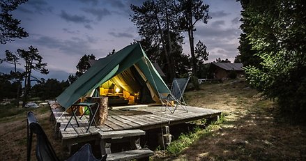 Stort tält, kvällstid, lampa som lyser