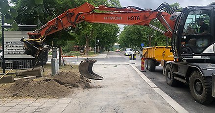 grävmaskin gräver i anslutning till stadsparken