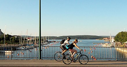 Två cyklister cyklar på cykelbana över Nybron i centrala Härnösand.