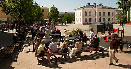 översiktsbild över torget med människor som sitter på bänkar och soffor