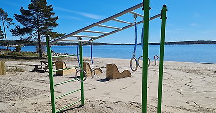 klätterställning på en sandstrand med havet i bakgrunden