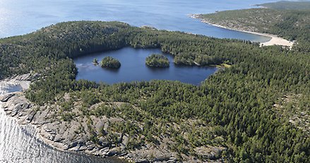 flygbild över kuststräcka med en sandstrand och en insjö.