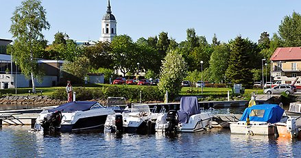 båtar vid en brygga med Härnösands domkyrka i bakgrunden