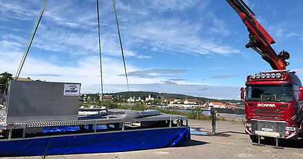 kranbil som lyfter en båtbottentvätt från marken