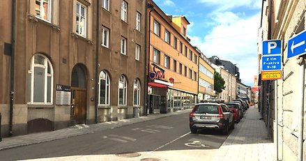 stadsgata med parkerade bilar på ena sidan