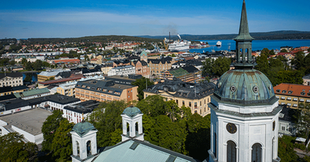 Flygbild, vit kyrka i förgrunden, hustak, vatten och längst bort två kryssningsfartyg