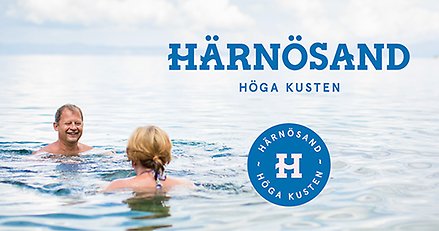 En bild på två människor som badar i havet. Över bilden ligger två logotyper där det står Härnösand Höga Kusten