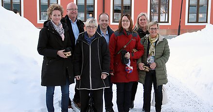 Gruppbild sju personer framför rådhuset