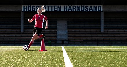 fotbollsspelare med fotboll på en gräsplan