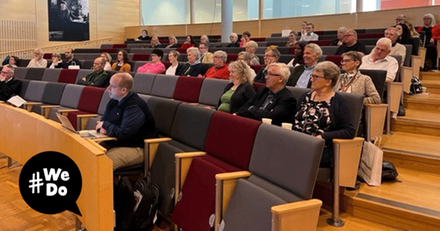 Flera personer som sitter i en utbildningssal och tittar mot scenen.