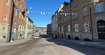 en stadsgata med ett flaggspel mellan husen