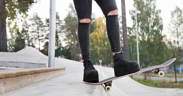 skateboardåkare synlig från knäna och nedåt i skateboardpark