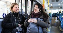 två kvinnor sitter tillsammans i en buss