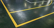 grönt golv i sprothall med gula och vita linjer
