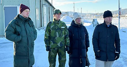 fyra personer står i en utemiljö