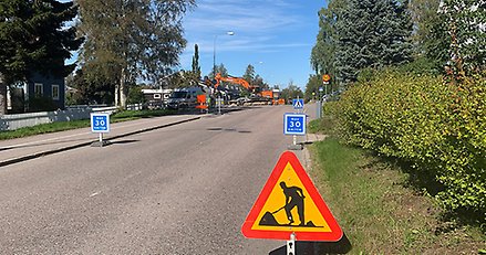 en gata med skyltar om vägarbete i förgrunden