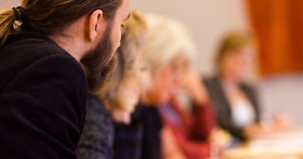 Oidentifierbara människor som sitter vid ett mötesbord.