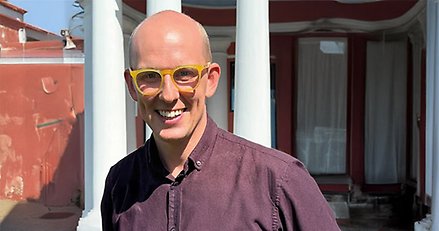 porträttbild på en man med gula glasögon