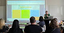 En kvinna föreläser för en grupp lärare. 