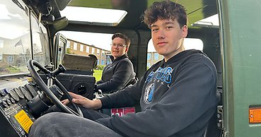 två unga killar sitter i en bandvagn