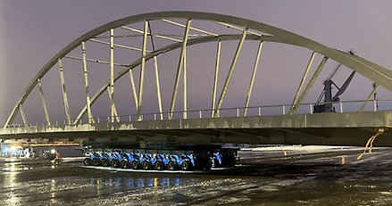 en stor bågbro står på en trailer med många tätt sittande hjul