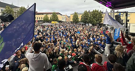 publikhav framför en scen på ett torg