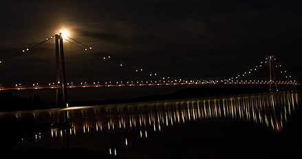 Högakustenbron speglar sig Ångermanälven på kvällen.